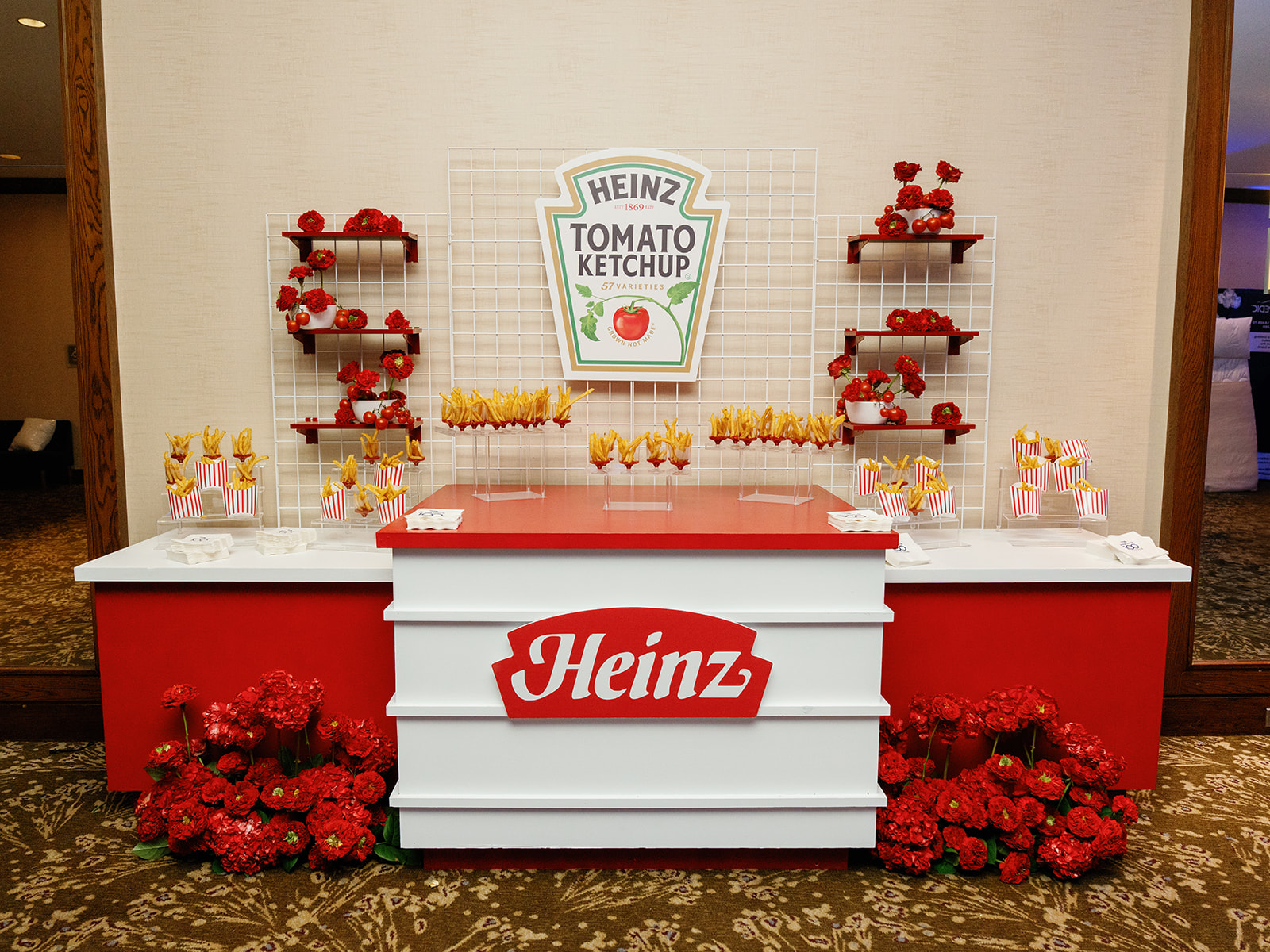 Custom Heinz-branded event installation with red floral arrangements and themed display styling at a corporate celebration.