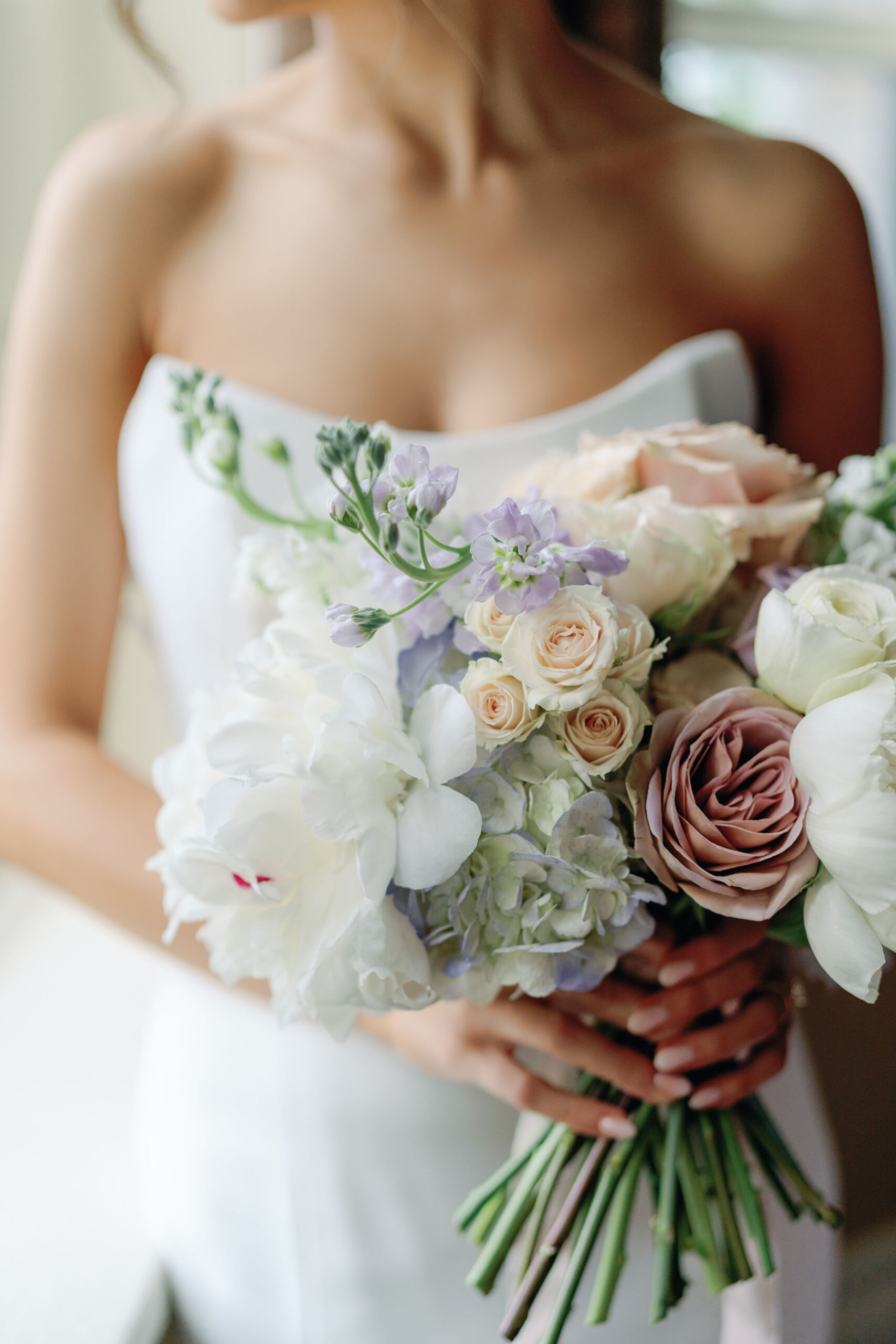 Bride holding garden-style wedding bouquet with peonies, garden roses, hydrangeas, and Amensia roses